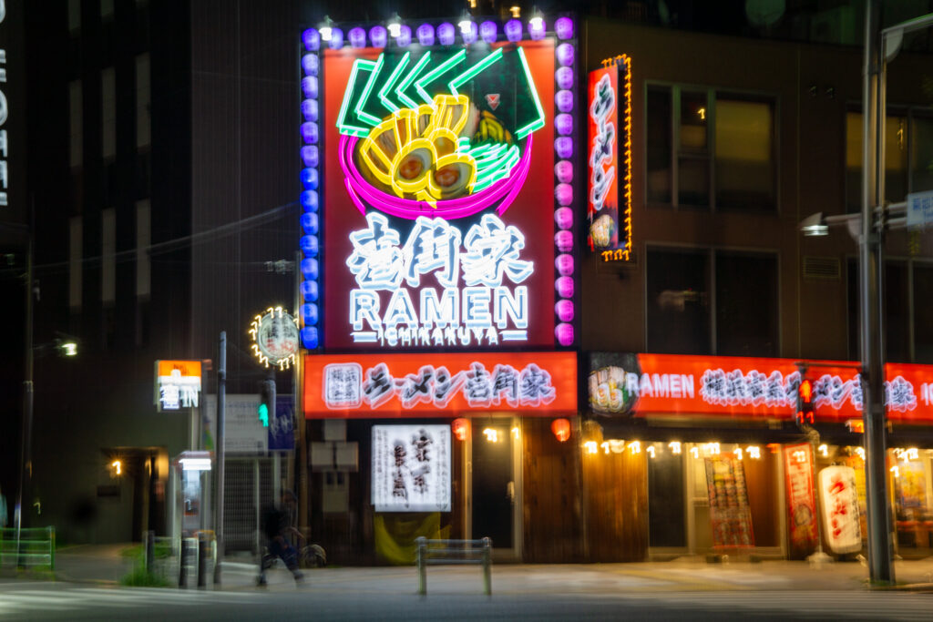 Neon: remen i podpis japoński na skrzyżowaniu ulicy w Tokyo