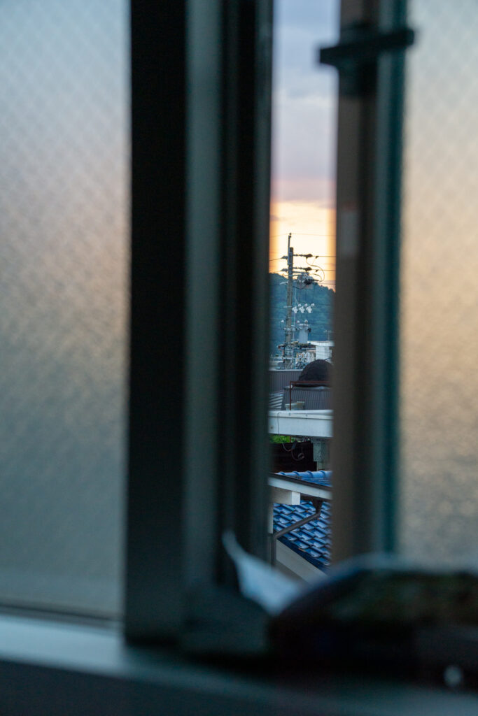 Widok z okna hotelu. Uchylone okno, widok na góry i antenę telewizyjną